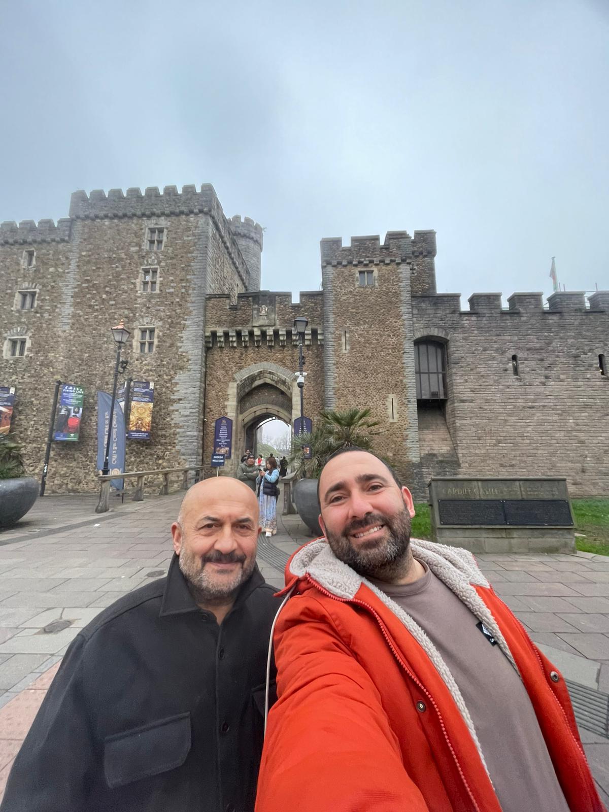 Two people in front of a historic castle