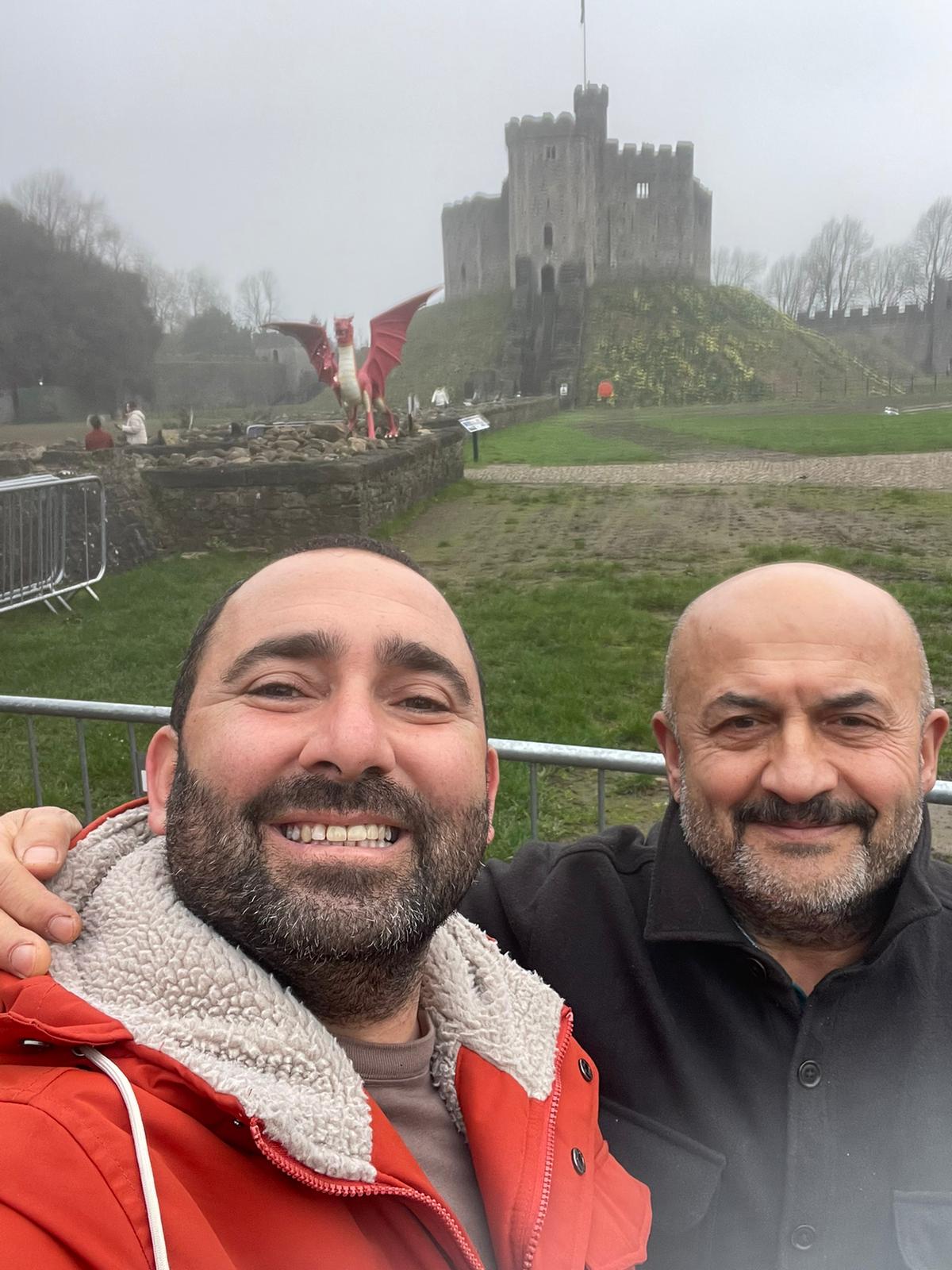 Two people taking a photo outside a historic castle